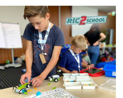 Ein Schüler baut an einem Lego-Fahrzeug im RIC2School Workshop