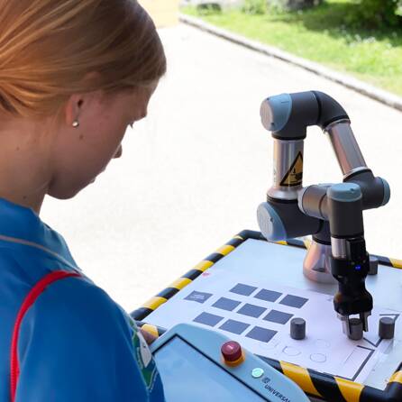 Ein Mädchen bedient einen Roboter des RIC_TECVans